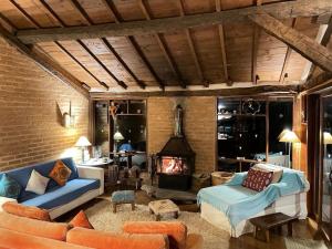 a living room with a couch and a fireplace at Santuário no coração do Matutu in Aiuruoca