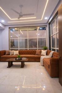 a living room with a couch and a coffee table at ll EMPYREAN STAYS ll G0DFATHER VILLA ll MASTERPIECE ll 4BHK ll AC ll LARGEST POOL ll in Lonavala