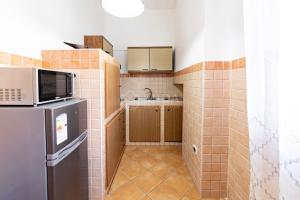 a small kitchen with a refrigerator and a microwave at Maridea Flat in Porto Cesareo +2 photos