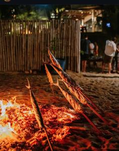 a fire in the sand next to a fence at Casa Tavarua na Taíba in Taíba +46 photos