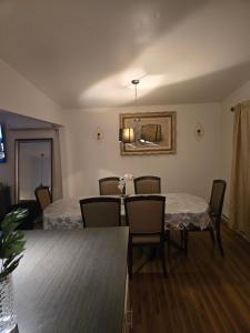 een woonkamer met 2 tafels en stoelen en een eetkamer bij Nature view retreat in Gatineau