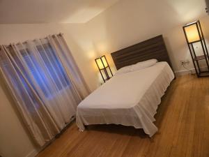 een slaapkamer met een wit bed en een raam bij Nature view retreat in Gatineau +21 foto's