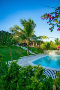 a swimming pool with palm trees next to a resort at Casa Tavarua na Taíba in Taíba