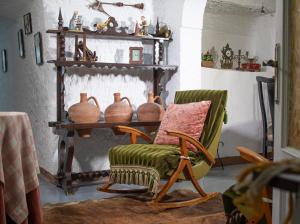 a living room with a chair and vases on shelves at Cueva Navarro in Gorafe