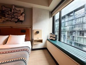 a bedroom with a bed and a large window at Moxy Miami Wynwood in Miami
