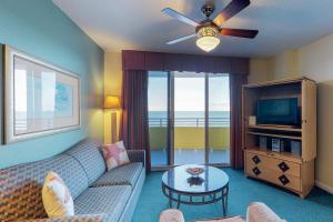 een woonkamer met een bank en een televisie bij Daytona Ocean Walk 2424A in Seabreeze