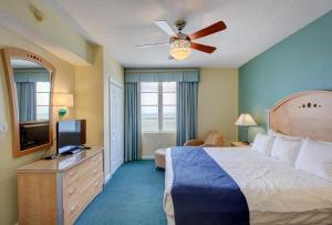 een slaapkamer met een bed en een flatscreen-tv bij Daytona Ocean Walk 2424A in Seabreeze +35 foto's