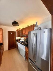 eine Küche mit Edelstahlkühlschrank und Holzschränken in der Unterkunft Malecón view mar apartment in Colorado + 1 Foto