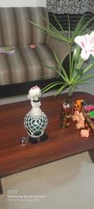 een houten tafel met een vaas en bloemen erop bij Lankadays in Negombo