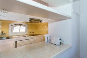 a kitchen with a sink and a counter with a appliance at Apartamentos Posidonia in Son Parc