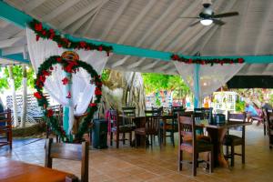 un restaurante con mesas y sillas con adornos navideños en Bonsai Rentals - West Bay Private Rooms, en West Bay