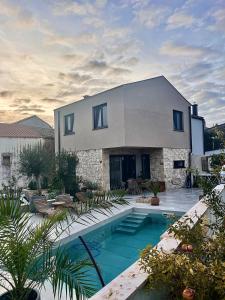 a house with a swimming pool in front of it at Guest house Noemi in Marčana