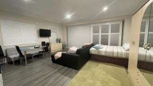 een slaapkamer met een bed en een bureau en een bed en een stoel bij Serene Guest House in Callala Beach