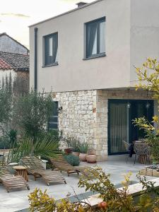 a patio with chairs and a building at Guest house Noemi in Marčana