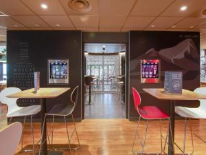 ein Restaurant mit Tischen und Stühlen in einem Raum in der Unterkunft ibis budget Montpellier Sud Près d'Arènes in Montpellier