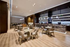 a restaurant with tables and chairs and a bar at Crowne Plaza Phnom Penh by IHG 金边皇冠假日酒店 Former VM Hotel in Phnom Penh