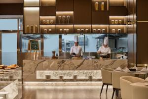 two chefs in the kitchen in a restaurant at Crowne Plaza Phnom Penh by IHG 金边皇冠假日酒店 Former VM Hotel in Phnom Penh +130 photos