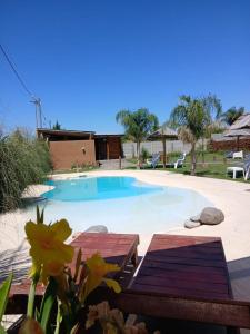 una grande piscina con due tavoli di legno accanto di Cabañas Punta Arena a San Pedro