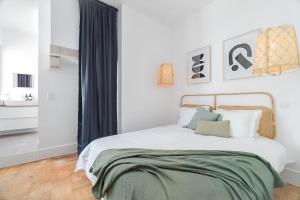 a bedroom with a bed with a green blanket on it at Charming Lisbon 2BR Apartment with Balcony in Lisbon