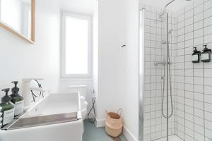 a white bathroom with a sink and a shower at Charming Lisbon 2BR Apartment with Balcony in Lisbon