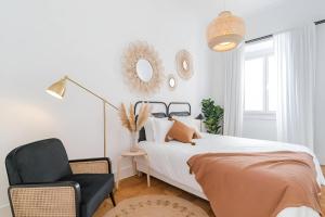 a bedroom with a bed and a chair and a mirror at Charming Lisbon 2BR Apartment with Balcony in Lisbon