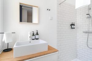 a white bathroom with a sink and a shower at Charming Lisbon 2BR Apartment with Balcony in Lisbon +2 photos