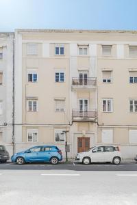 two cars parked in front of a building at Charming Lisbon 2BR Apartment with Balcony in Lisbon