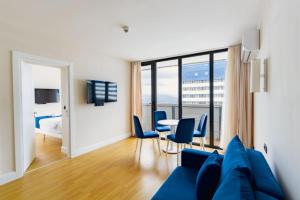 ein Wohnzimmer mit einem blauen Sofa und einem Tisch in der Unterkunft ORBI CITY - Center Apartments in Batumi