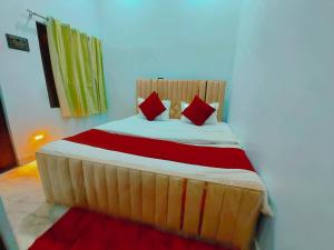 una cama con almohadas rojas en una habitación en THE GRAND STAY 600 Meters from temple, en Varanasi