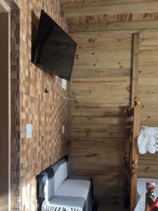 een kamer met een muur, een tv en een bank bij Morada do Sol Petar in Iporanga