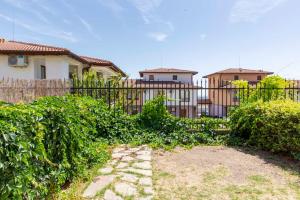 einen Zaun mit Büschen vor einem Haus in der Unterkunft Harmony Hills Tomovi Casa 16 in Rogachevo