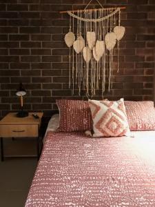 1 cama con almohadas rojas y blancas y pared de ladrillo en Sabaneta Parque, Wifi,Excelente vista ,Central, en Sabaneta 6 fotos más
