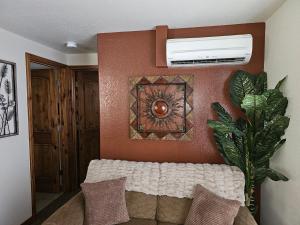 a living room with a couch and a fan on a wall at Alpenglow One Bedroom One Bath – A09 in Ouray +2 photos