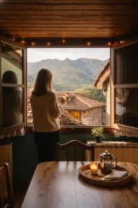 Una mujer mirando por una ventana a una mesa en Montegrande, entorno mágico rodeado de montañas, en La Plaza