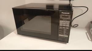 Luxury furnished 1BHK apartment Maria Vista في أبوظبي: يوجد فرن ميكروويف أسود على منضدة +15 صورة