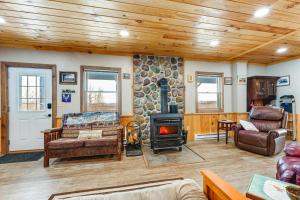 un soggiorno con camino e parete in pietra di Panoramic Upstate Views Tranquil Home on 70 Acres a Prattsburg