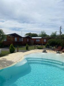 una grande piscina davanti a una casa di Cabañas Punta Arena a San Pedro