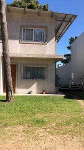 een huis met een boom ervoor bij Abadejo in Pinamar