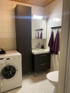 a bathroom with a washing machine and a washer at Loft house Karihaara in Kemi