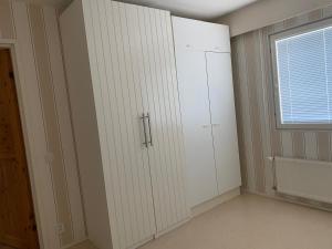a room with white cabinets and a window at Loft house Karihaara in Kemi