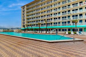 a hotel with a swimming pool in front of a building at Daytona Harbour Beach Resort Unit 808 in Daytona Beach