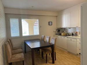 a kitchen with a dining room table and chairs at Loft house Karihaara in Kemi