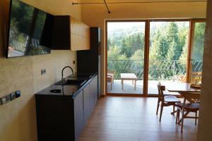 a kitchen with a large window and a table with chairs at Тхаті in Yablunytsya