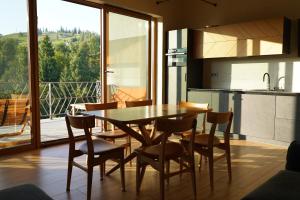 a kitchen and dining room with a table and chairs at Тхаті in Yablunytsya +10 photos