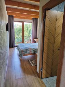 a bedroom with a bed and a sliding glass door at Тхаті in Yablunytsya