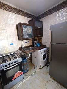 a kitchen with a stove and a refrigerator at Sheraton Palace 1 in Alexandria +1 photo