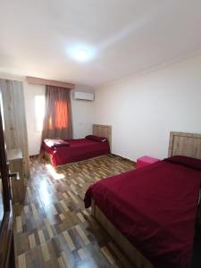 a hotel room with two beds and a window at Sheraton Palace 1 in Alexandria