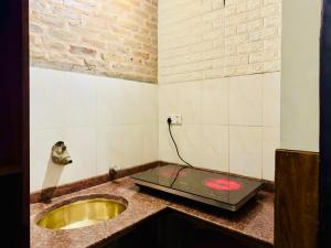 a kitchen with a sink and a microwave on a counter at Newa Home in Kathmandu