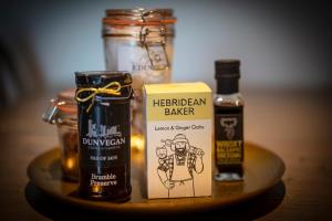 een tafel met een pot honing en een fles alcohol bij Dunvegan Castle Rose Valley Cottage in Dunvegan