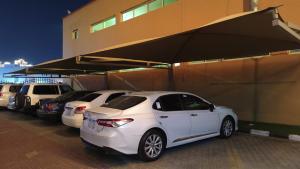 a row of white cars parked next to a building at فندق جراند روز in Najran